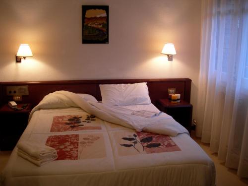 سرير أو أسرّة في غرفة في Hosteria Catalana