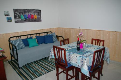 Un dormitorio con una cama y una mesa con sillas. en La Casetta di Andrea & Vale, en Termini Imerese