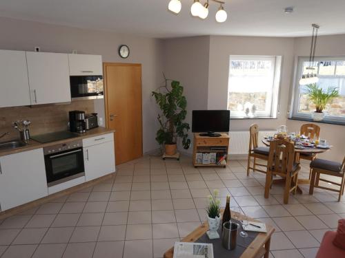 a kitchen and living room with a table and chairs at Sch ne Wohnung in der Moselregion in Kinheim