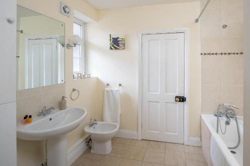a bathroom with a sink and a toilet and a tub at Skyline Serviced Apartments - London Bridge in London