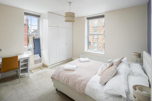 Skyline Serviced Apartments - London Bridge في لندن: غرفة نوم بيضاء مع سرير ومكتب