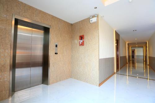 an elevator lobby with a metal door in a building at Triple Trees Hotel in Pathum Thani