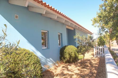 a blue house with a fence in front of it at Comporta House in Comporta