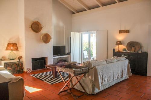 a living room with a couch and a fireplace at Comporta House in Comporta