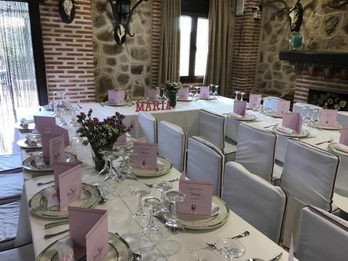 a long table with white chairs and pink cards on it at Hotel Rural La Cabrera in Robledo del Buey