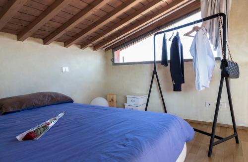 a bedroom with a blue bed and a window at The Artist's Loft in Lucca