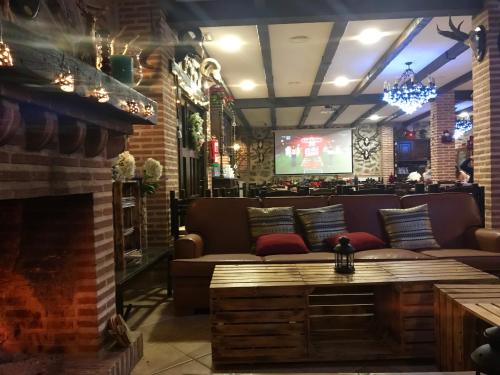 a living room with a couch and a fireplace at Hotel Rural La Cabrera in Robledo del Buey