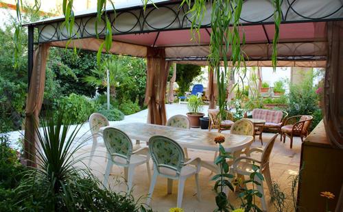 a patio with a table and chairs under a pavilion at B&B IreneMarchese Gluten Free in Taviano