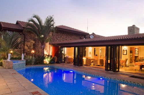 uma piscina em frente a uma casa em Schneiders Boutique Hotel em White River