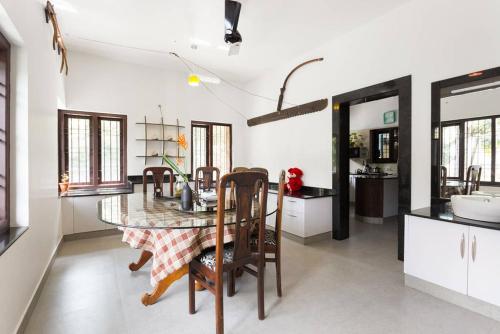 a kitchen and dining room with a table and chairs at Sceva's Garden Home in Munnar