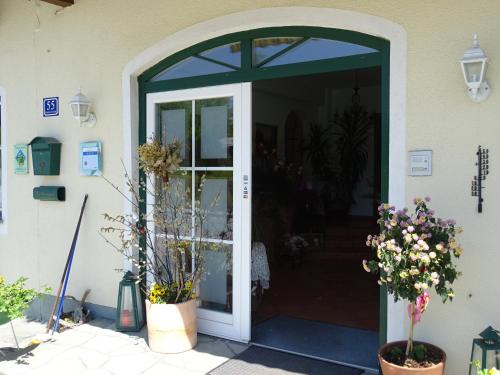 an entry door to a house with potted plants at Pension Bayrhammer in Faistenau