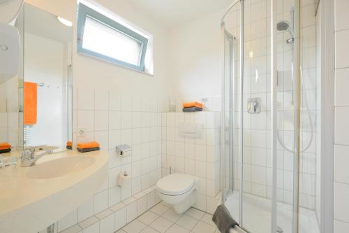 a bathroom with a toilet and a sink and a shower at Werkhof Hotel in Hannover