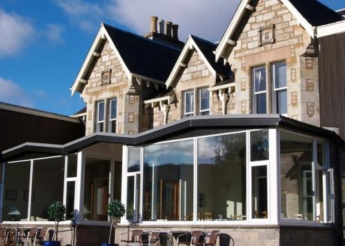 a large house with glass doors and windows at The Acarsaid - Pitlochry in Pitlochry