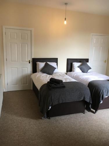a bedroom with two beds and a door at Albion House in Doncaster