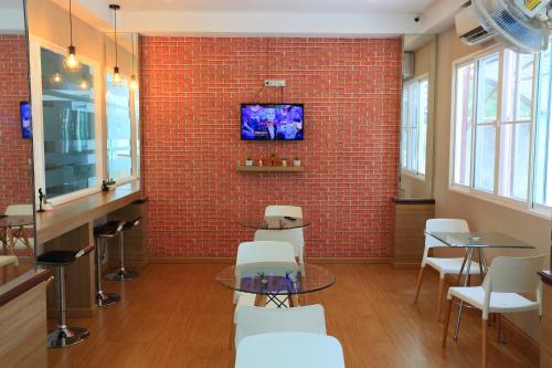 a room with a table and chairs and a brick wall at Triple Trees Hotel in Pathum Thani