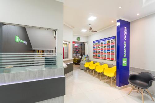 a waiting area at a store with yellow chairs at Rezende Suítes Hotel in Balneário Camboriú