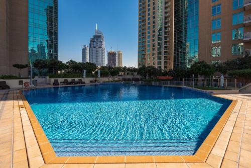 a large swimming pool in the middle of a city at One Bedroom Apartment Dubai Fountain & Old Town View by Auberge in Dubai