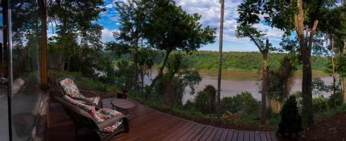 a wooden deck with a view of a river at Tupa Lodge in Puerto Iguazú