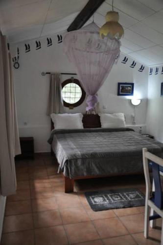 a bedroom with a large bed and a window at Hotel Napoleon Lagune in Lomé