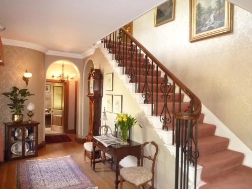 a living room with a staircase with a table at Rectory Farm in Cambridge