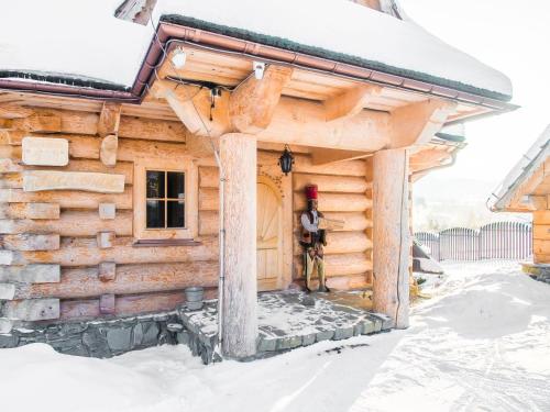 a log cabin with snow on the roof at TatryTop Panorama Lux Spa in Kościelisko