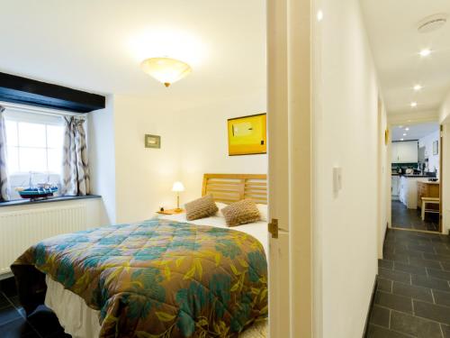 Un dormitorio con una cama con una colcha colorida. en Museum Apartment, en Looe