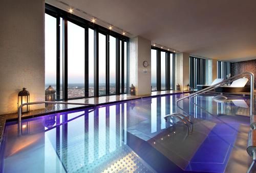 a swimming pool in a hotel with large windows at Eurostars Madrid Tower in Madrid
