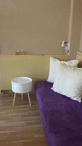 a bed with a purple blanket and a table at Ferienhaus Peggy in Kurort Oybin