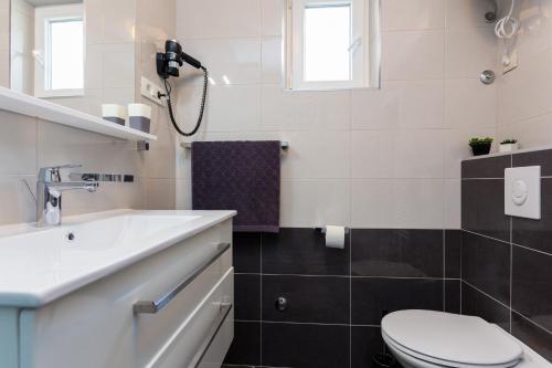 a white bathroom with a sink and a toilet at Guesthouse Ivona in Dubrovnik