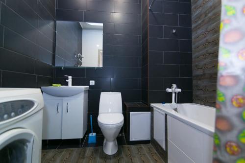 La salle de bains est pourvue de toilettes, d'un lavabo et d'une baignoire. dans l'établissement Apartment Faraon 5, à Soumy