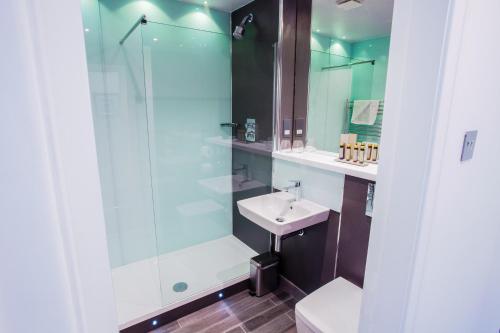 a bathroom with a glass shower and a sink at Red Hall Hotel in Walmersley