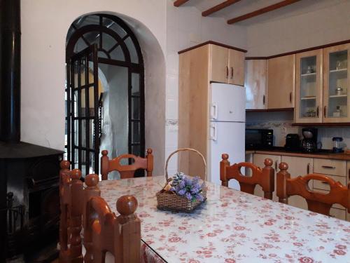 a kitchen with a table with a basket of flowers on it at Casa de La Abuela Pepi in Aracena