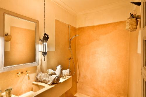 a bathroom with a sink and a mirror at Hotel & Spa Riad Al Jazira in Marrakech