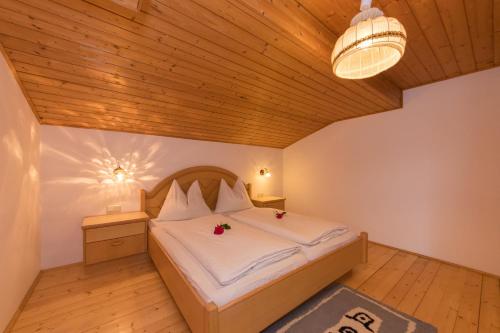 een slaapkamer met een bed en een houten plafond bij Teufenbachgut in Lend