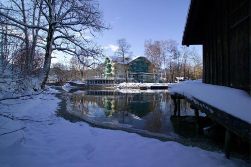 a river with snow on the ground next to a building at Seevilla Altaussee in Altaussee