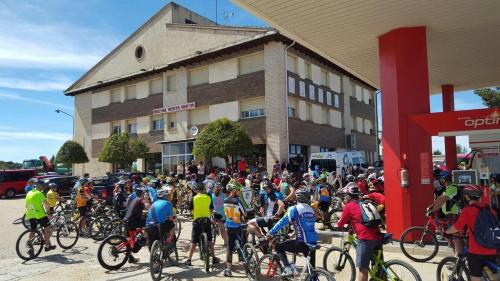 un gran grupo de personas montando bicicletas frente a un edificio en Hotel Venta Nueva, en Calatañazor