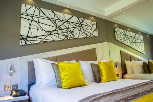 a bedroom with a large bed with yellow pillows at Red Hall Hotel in Walmersley