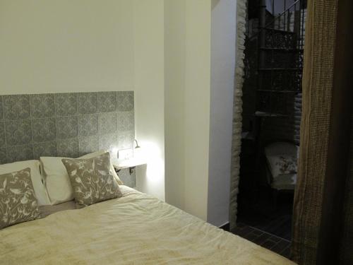 セビリアにあるThe Green Balconyのベッドルーム1室(ベッド1台、ヘッドボード、ランプ付)