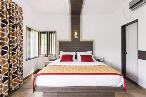 a bedroom with a large bed with red pillows at Sceva's Garden Home in Munnar