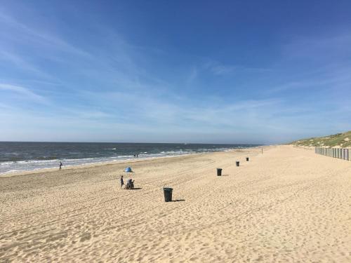 a beach with a row of trash cans in the sand at Ferienhaus am Meer mit Kamin & Sauna - Seestern 251 in Julianadorp