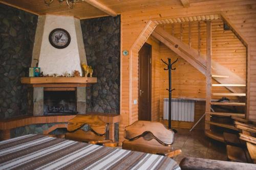 um quarto com lareira e uma escada num chalé de madeira em Kryvyi brid em Yaremche