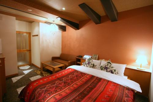 Habitación de hotel con cama y sofá en Hotel Aura Resort Ⅱ Kashiba (Adult Only), en Nara