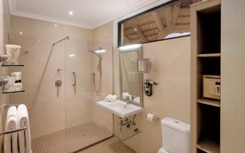 a bathroom with a shower and a sink and a toilet at Mokuti Etosha in Namutoni