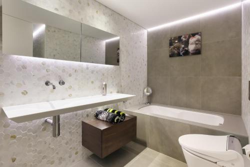 a bathroom with a sink and a tub and a toilet at 3 Bedroom Darling Harbour Apartment in Sydney