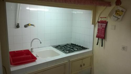 a kitchen with a sink and a stove at Casal São João Cottages 106 in Fajã da Ovelha