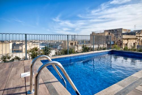 a swimming pool on the roof of a building at 66 Saint Paul's & Spa in Valletta