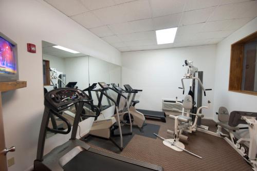 a gym with a row of treadmills and ellipticals at Days Inn & Suites by Wyndham Laredo in Laredo
