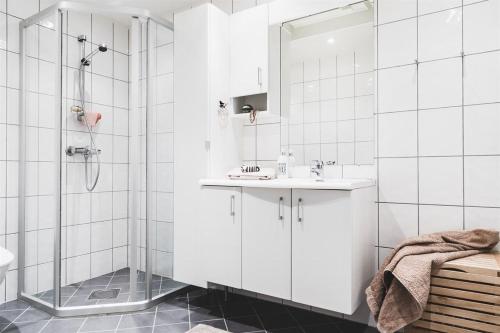 a white bathroom with a shower and a sink at Nice, Modern Apartment in Central Bergen in Bergen