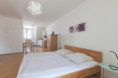 een slaapkamer met een bed met witte lakens erop bij Altstadtloft am Martinstor in Freiburg im Breisgau