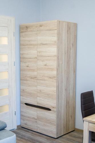 a wooden cabinet in the corner of a room at Apartamenty Centrum Chodzież in Chodzież